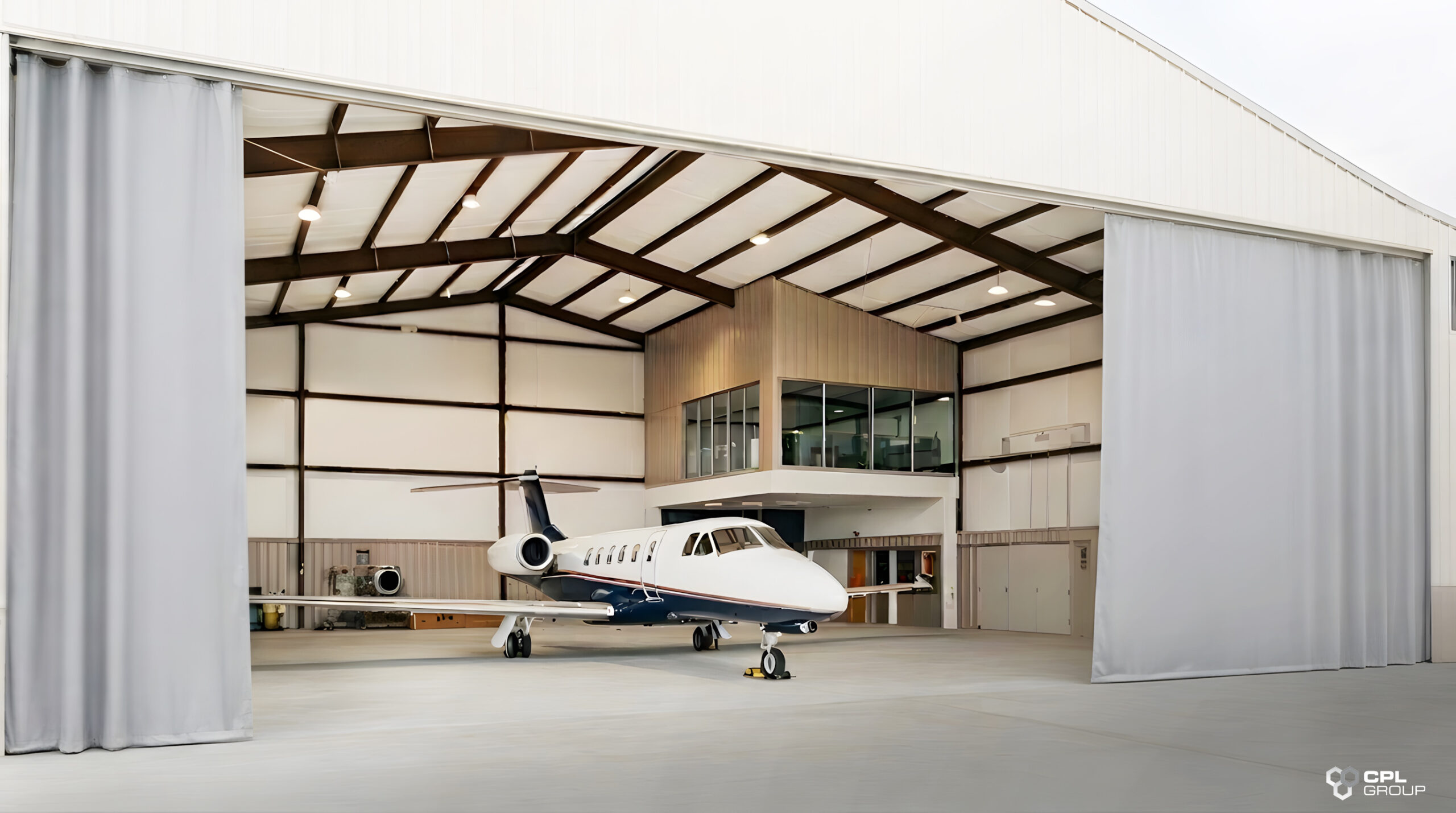 Aircraft inside a hangar fitted with large flexible curtain doors for space separation